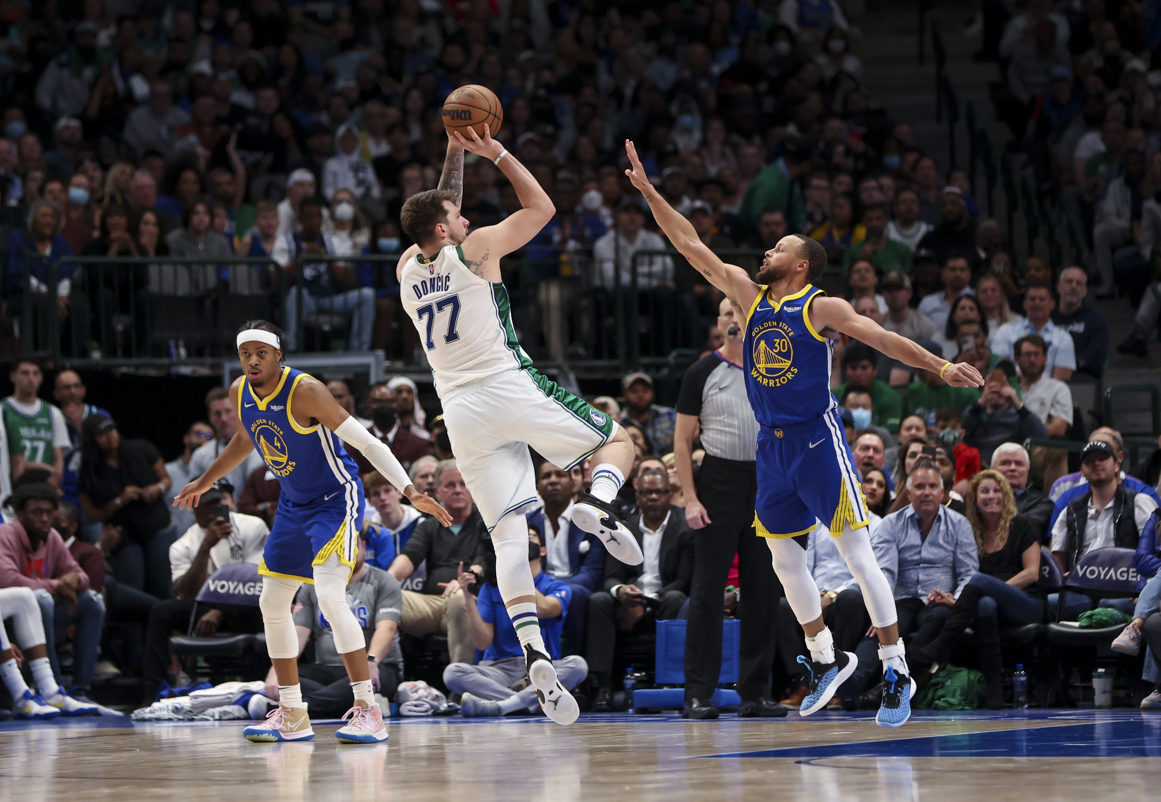 Dallas Mavericks guard Luka Doncic (77) shoots over Golden State Warriors guard Stephen Curry (30) during the game at American Airlines Center.