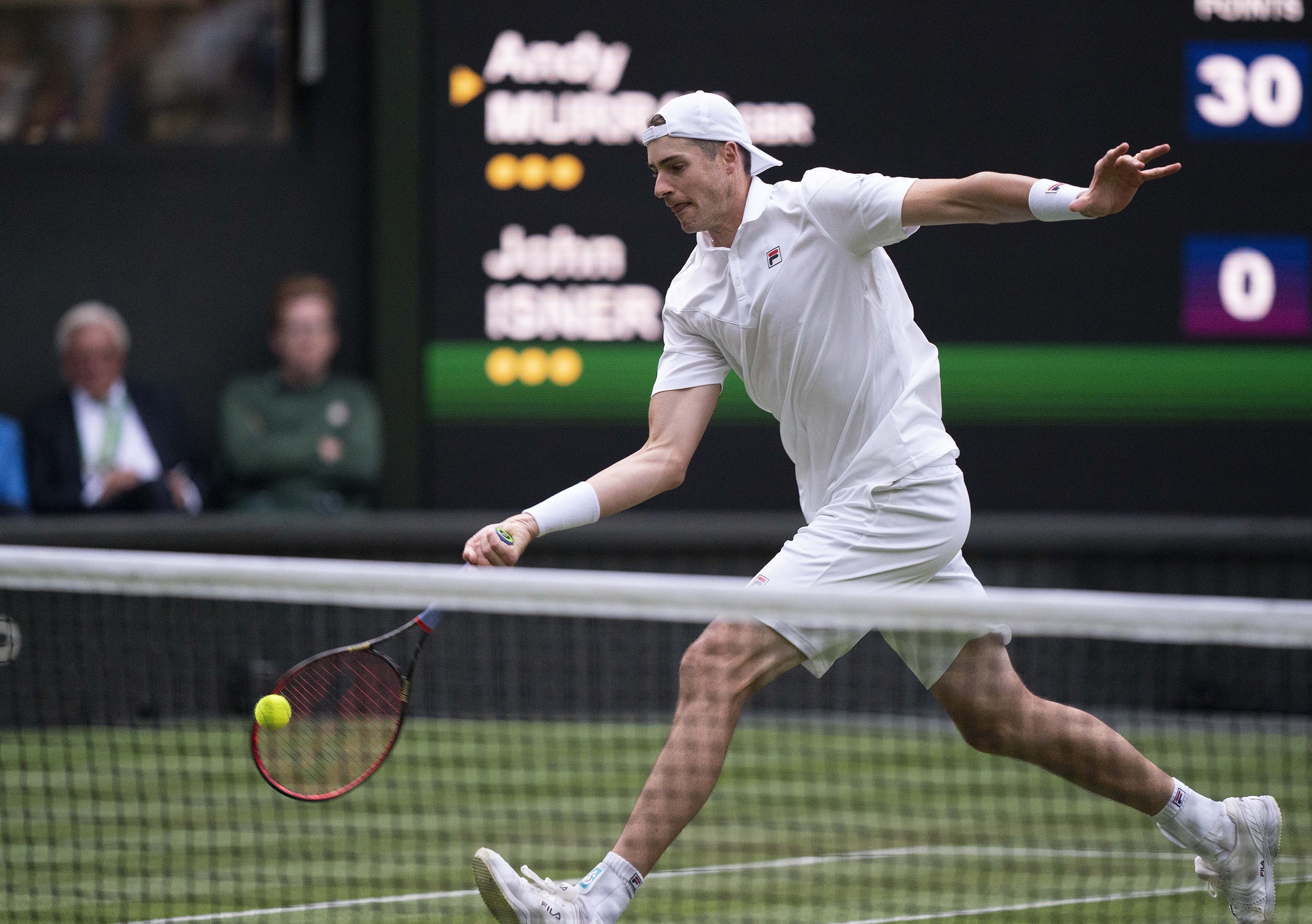 John Isner (USA) returns a shot during his second round match against Andy Murray (GBR) on day three at All England Lawn Tennis and Croquet Club.