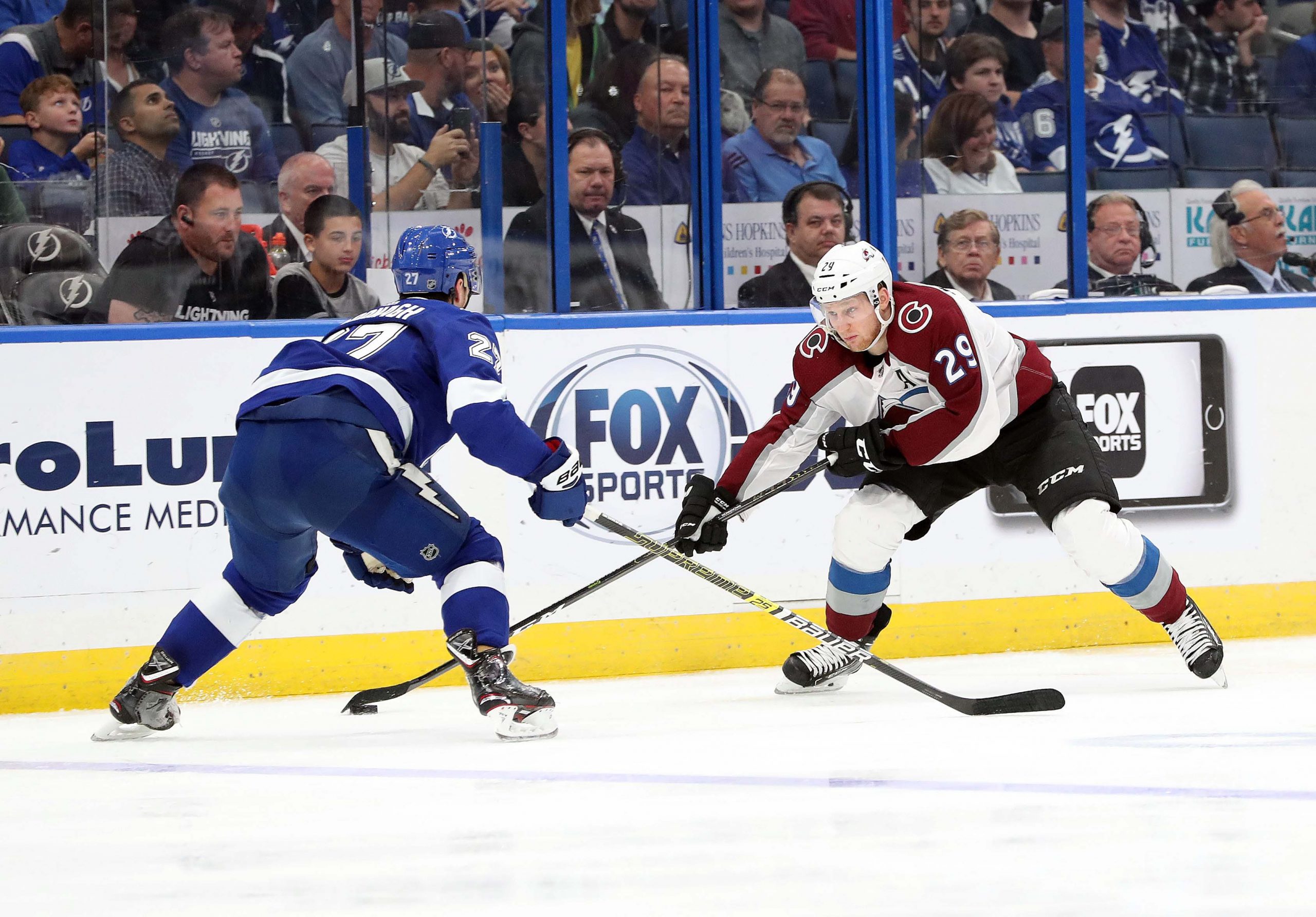 Avalanche MacKinnon skates around Lightning McDonagh