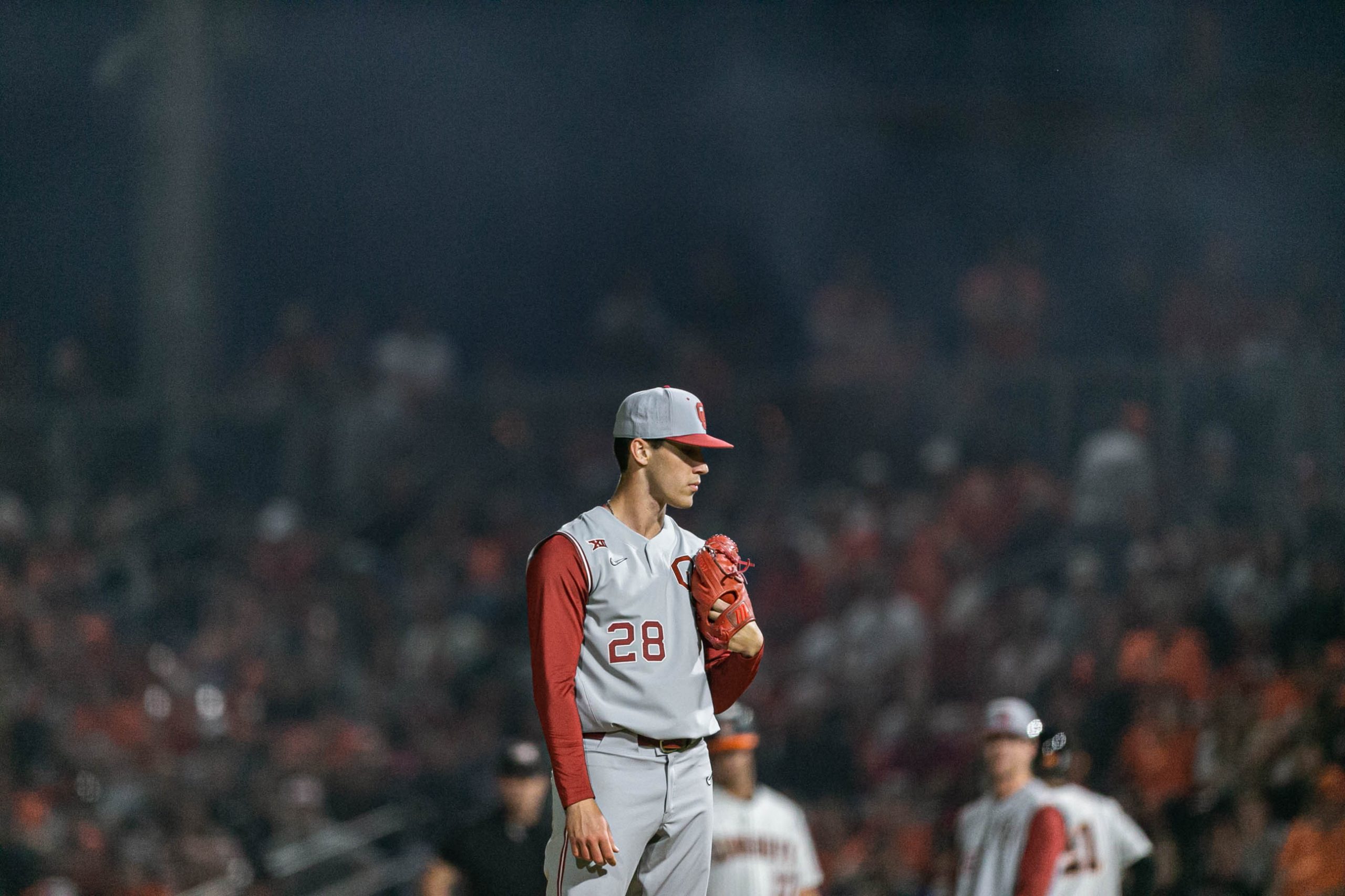 Smoke fills the field as David Sandlin (28) looks to pitch as the Oklahoma Sooners take on the Oklahoma State Cowboys at O'Brate Stadium on OSU campus in Stillwater on Saturday, April 9, 2022