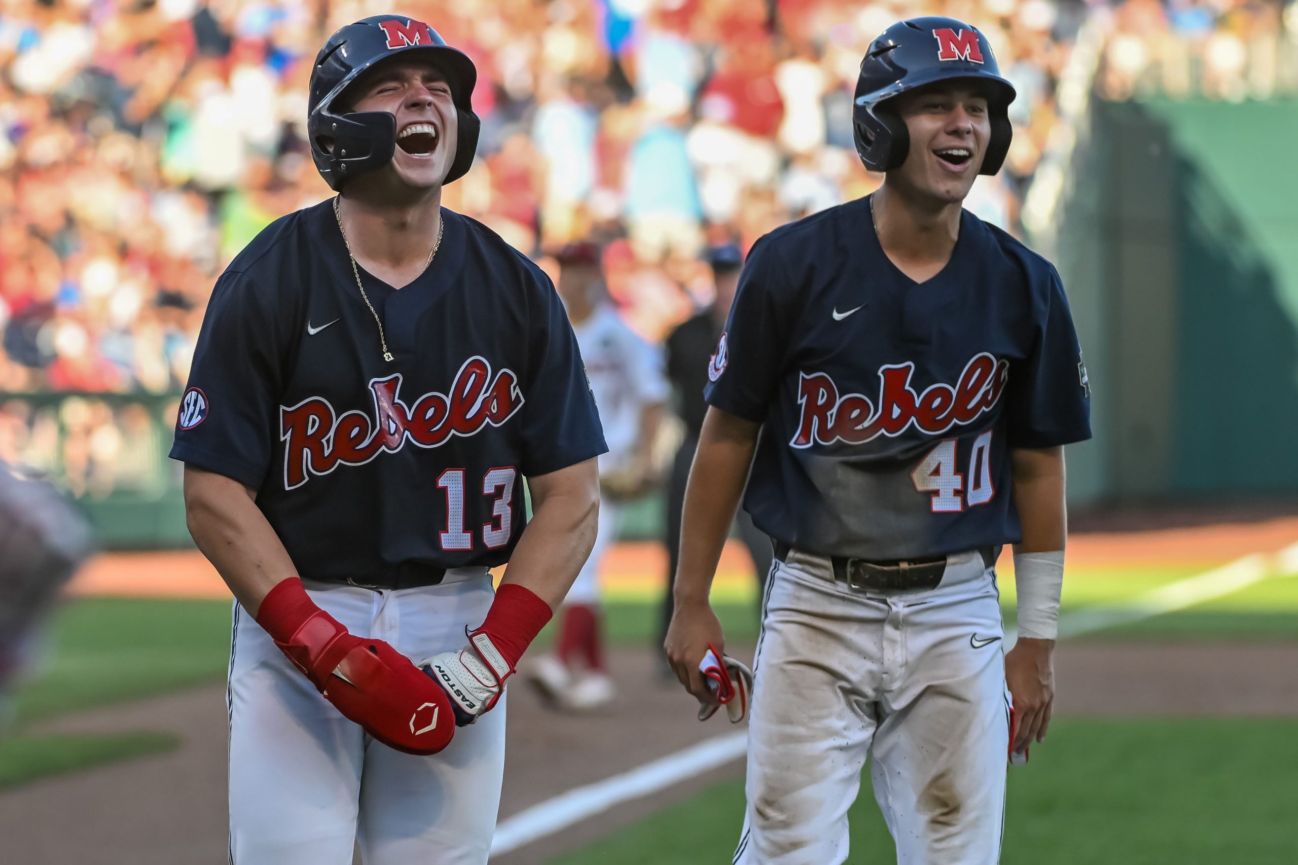 Ole Miss Rebels third baseman Garrett Wood (40) and catcher Hayden Dunhurst (13) celebrate scoring against the Arkansas Razorbacks in the third inning at Charles Schwab Field.