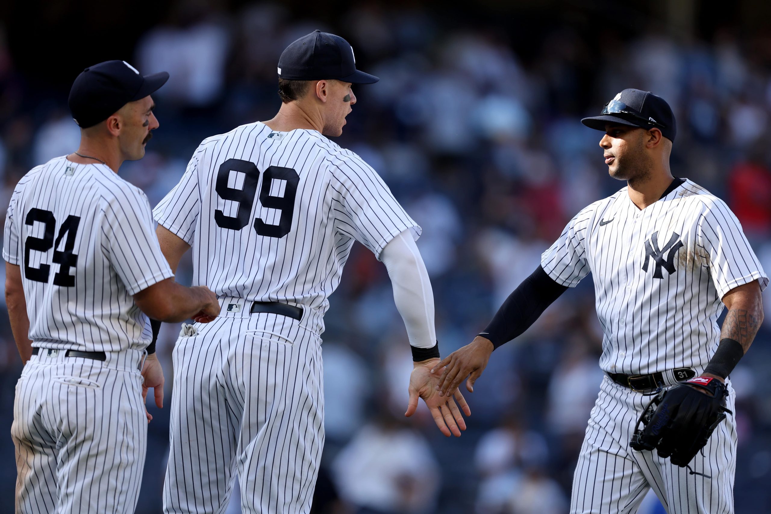 New York Yankees right fielder Matt Carpenter (24) and designated hitter Aaron Judge (99) and center fielder Aaron Hicks (31) celebrate after defeating the Kansas City Royals at Yankee Stadium.