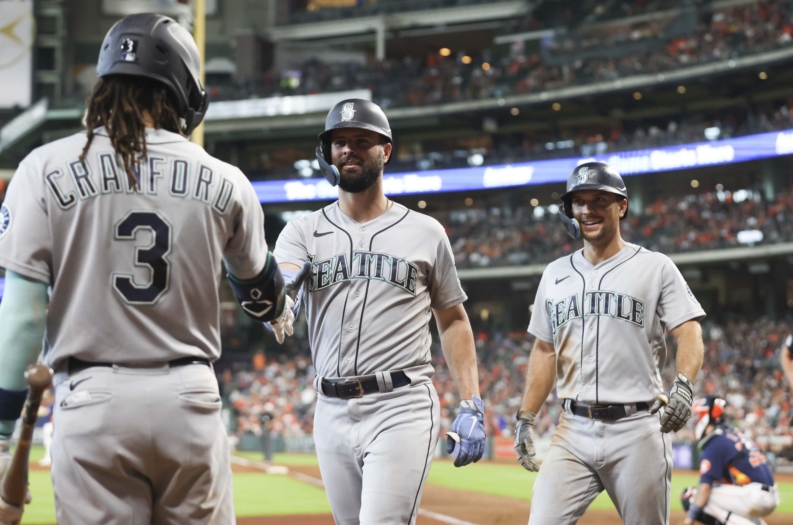 Seattle Mariners shortstop J.P. Crawford (3) and center fielder Adam Frazier (26) celebrates left fielder Jesse Winker (27) two-run home run against the Seattle Mariners in the eighth inning at Minute Maid Park.
